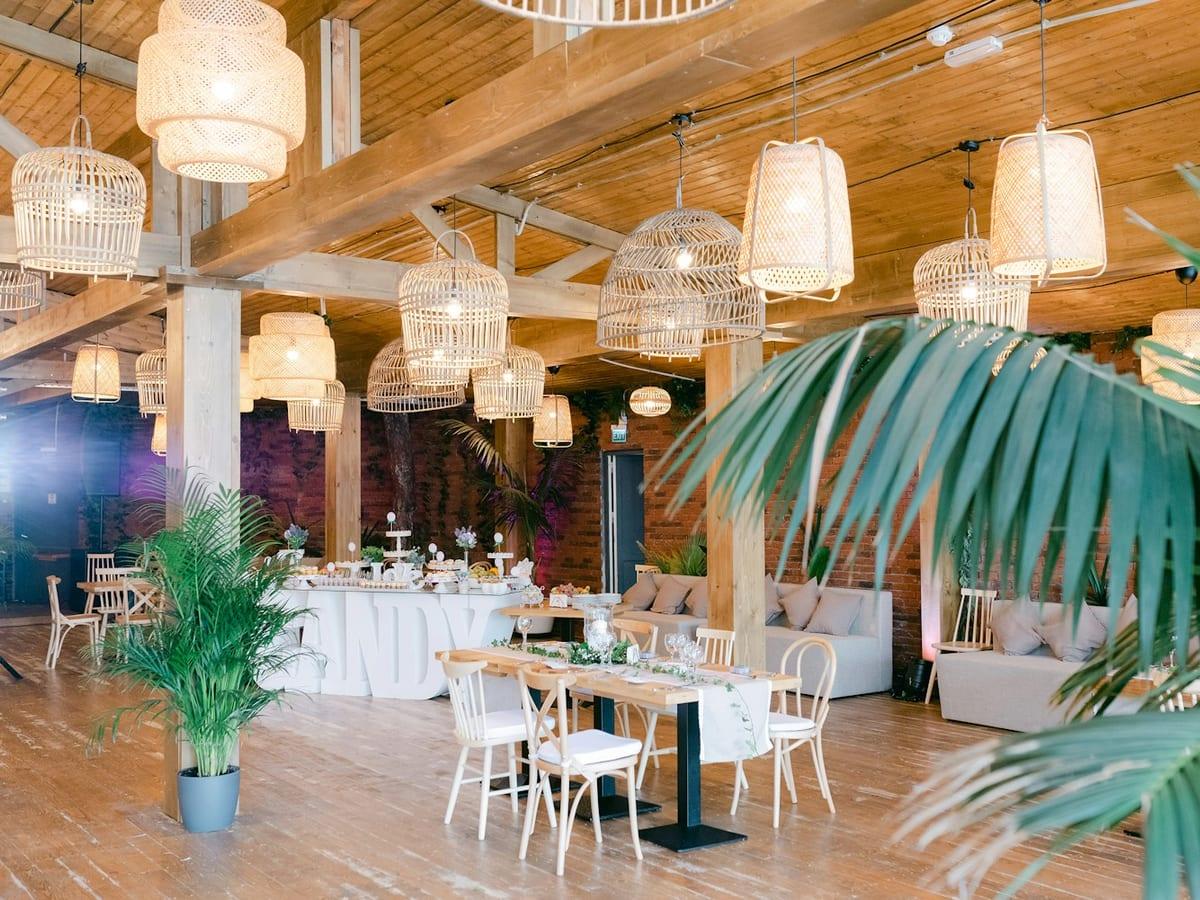 Salón montado para una boda con mesas largas y velas